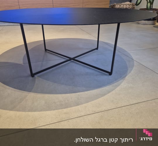 שולחן עגול עם רגלי מתכת על רצפת אריחים